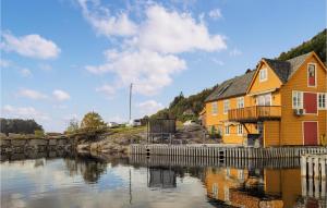 4 Bedroom Awesome Home In Strandvik的靠近水体的黄色和红色建筑