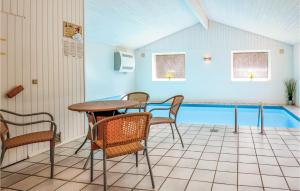 Sillerslev麦达曼度假屋 的一个带桌椅的庭院和一个游泳池