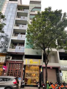 胡志明市Mia Hotel的一座高楼前的树