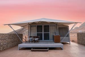 沙迦Moon Retreat by Sharjah Collection的沙漠中带桌椅的帐篷