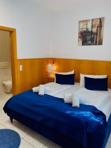 斯图加特拉费尔酒店的一间卧室配有一张带蓝白色床单的大床