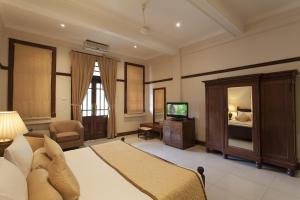 康提瑞士酒店的一间卧室配有一张床和一台电视