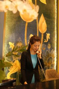 波来古市Pleiku Hotel by Gia Lai Tourist的穿着西装的女人在手机上讲话