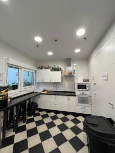 塞维利亚A2C旅舍的厨房配有白色橱柜和 ⁇ 格地板