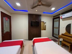 BhadrāvatiSTAYMAKER DV Residency的酒店客房设有两张床和钢琴