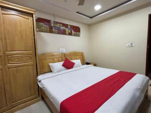 BhadrāvatiSTAYMAKER DV Residency的一间卧室配有红色和白色床单