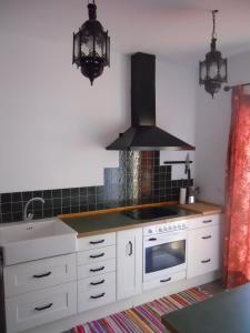 卡塞雷斯Naturalia: La casita con Patio的厨房配有白色橱柜和炉灶烤箱。