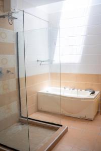 蒙巴萨SANDS AND ROCKS APARTMENT的带浴缸和玻璃淋浴间的浴室。
