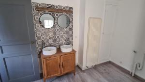 布尔格伊Maison Bourgueil的浴室设有两个水槽,墙上设有镜子