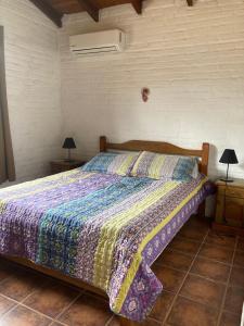 皮里亚波利斯卡萨7塞罗斯度假屋的一间卧室配有一张带五颜六色棉被的床