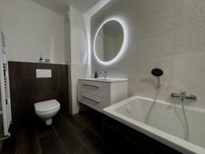 新扎姆基City Comfort Retreat的浴室配有卫生间、浴缸和水槽。