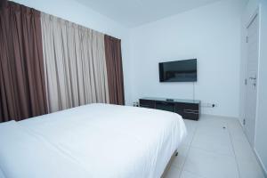 迪拜Home Away Holiday Homes的卧室配有白色的床和电视。