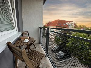 新扎姆基City Comfort Retreat的阳台配有两把椅子和一张桌子,还有一个窗户。