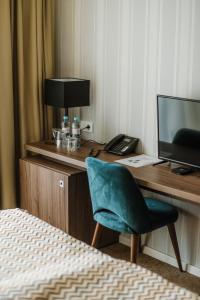 尼什Hotel Nais的客房设有一张桌子、一台电脑和一把椅子