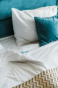 尼什Hotel Nais的一张带白色床单和蓝色枕头的床