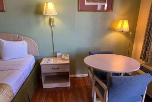 胡尔伯克霍尔布鲁克旅程住宿酒店的客房设有1张床、1张桌子、1张床和1张桌子及椅子。