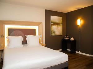 达喀尔诺富特达喀尔酒店的一间卧室配有一张带白色床单的大床