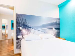 坎佩尔坎佩尔宜必思尚品酒店的卧室的墙上挂有海滩壁画