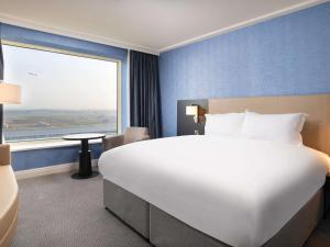 霍利索菲特伦敦盖特威克酒店的一张位于酒店客房的大床,设有大窗户