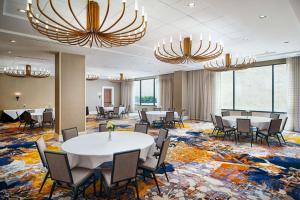 亚特兰大Embassy Suites by Hilton Atlanta Buckhead的一间会议室,配有桌椅和吊灯