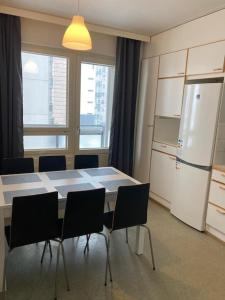 万塔Kotimaailma - Kalustettu saunallinen asunto kuudelle的厨房配有桌椅和冰箱。
