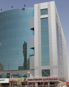 利雅德Carawan Al Khaleej Hotel Olaya的一座高大的玻璃建筑,上面有时钟