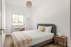 里斯本JOIVY Striking flat in Benfica的白色的卧室设有床和窗户