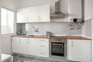 里斯本JOIVY Striking flat in Benfica的厨房配有白色橱柜和水槽