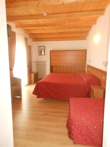 圣奇诺·迪·蒙塔尼亚蒙塔巴尔迪那酒店的一间卧室设有两张床和木制天花板