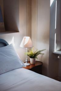 阿夸维瓦皮切纳Hotel Oviv dimora del borgo的一间卧室配有一张床和一张桌子上的台灯