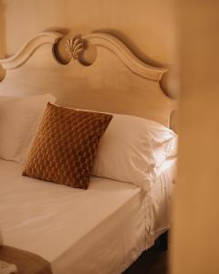 阿夸维瓦皮切纳Hotel Oviv dimora del borgo的白色的床和棕色枕头
