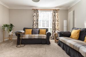 爱丁堡Modern Two Bedroom Apartment, Roseburn, Edinburgh - Free Parking的带沙发和窗户的客厅