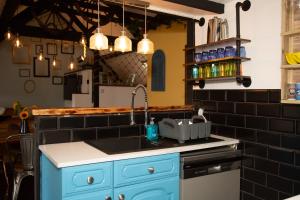 托基Quirky Boutique 1840s Stable的厨房配有蓝色水槽和黑色瓷砖