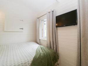 KembleBeech的一间小卧室,配有一张床和一台平面电视