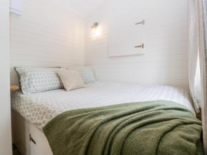 KembleBeech的白色墙壁的客房内的一张小床