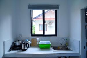 暹粒Daisy Angkor Bungalow的带水槽的厨房台面和窗户
