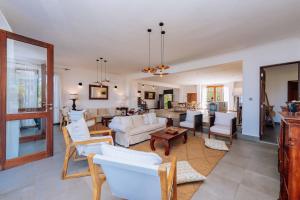 马特姆维Karabai Villa的一间带白色沙发的客厅和一间用餐室