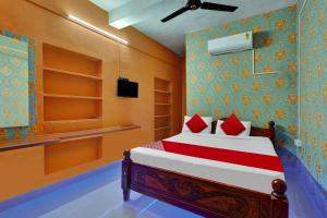 马杜赖OYO Flagship Ar Grand的一间卧室配有红色枕头的床