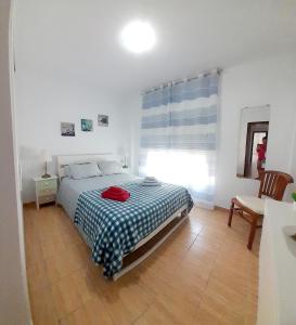 圣伊西德罗Appartamento Mochiri - San Isidro的一间卧室配有一张床、一张桌子和一个窗户。