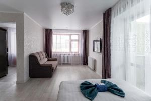 彼得罗巴甫洛夫斯克Альпина的一间卧室配有一张床、一张沙发和一把椅子