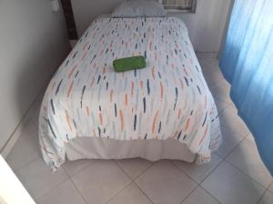 比勒陀利亚Las Palmas Day & Night Guest House的一张带白色棉被的床,上面有绿色物品