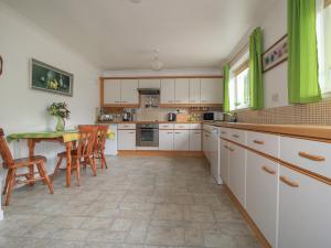 斯托诺韦Dunard Villa的厨房配有白色橱柜和桌椅
