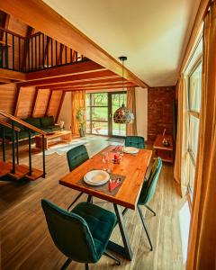 布朗Aruna Bran的一间带木桌和绿色椅子的用餐室
