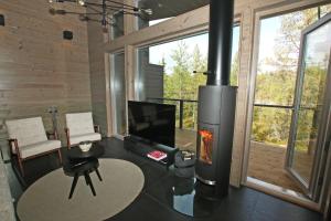 库萨莫Villa Kanger Ruka 2的客厅设有壁炉和电视。