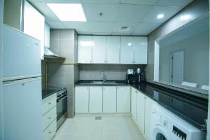 迪拜Home Away Holiday Homes的厨房配有白色橱柜和水槽