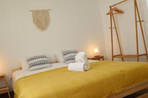 布德恩斯Casa Vento Budens的一间卧室配有黄色的床和毛巾