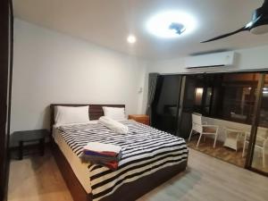 南芭堤雅帕拉塔姆纳克吉奥姆特恩山丘度假酒店的一间卧室配有一张带黑白条纹毯子的床