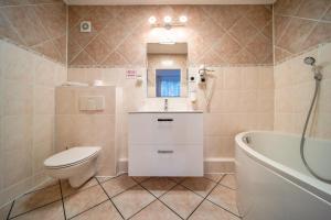 波兹南波兹南格罗马达酒店的浴室配有卫生间、盥洗盆和浴缸。