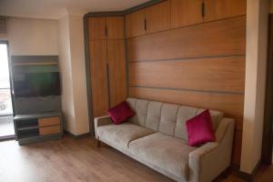 阿克恰科贾Ceneviz Suit Hotel的客厅配有带2个粉红色枕头的沙发
