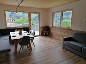 海因岑贝格Montepart Zillertal的客厅配有桌子、沙发和窗户。